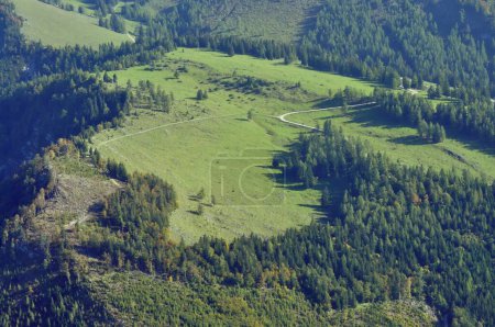 Luftaufnahme von Alpen, Wald und Feldern rund um Salzburg im Sommer. Luftaufnahme ländlicher Gebiete umgeben von Waldbergen im Salzammergut, Österreich