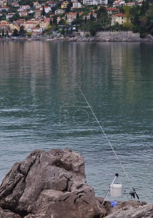 Téléchargez les photos : Canne à pêche sur la côte maritime en Croatie. cannes à pêche dans la mer Adriatique sur la côte d'Opatija en Croatie occidentale. - en image libre de droit