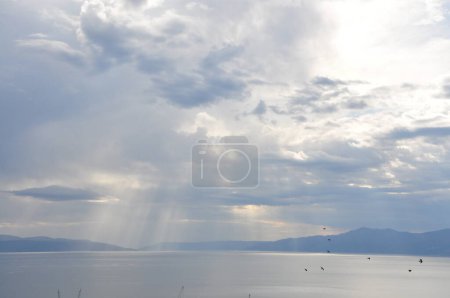 Möwenvögel fliegen mit Sonnenstrahlen im Hintergrund über das Wasser. Vogel fliegt über Sonnenstrahlen. Malerischer Blick auf das Meer gegen den Himmel.