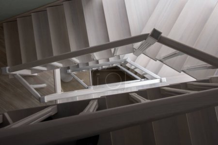Téléchargez les photos : Fragment d'un escalier en bois blanc. Escaliers, piliers, balustres, mains courantes en frêne - en image libre de droit