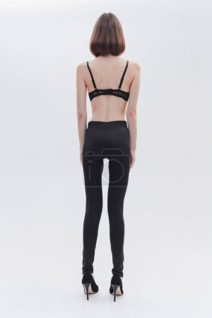 Foto de Una chica con anorexia se volvió hacia atrás, espina dorsal y costillas visibles sobre fondo blanco. - Imagen libre de derechos