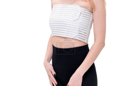 After giving birth, a woman wears a medical belt to support her breast. Isolated on white background.