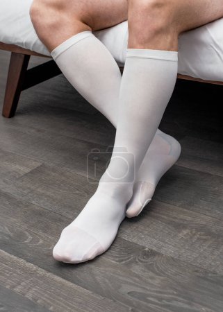 Sport Man Putting On Medical White Medias de compresión en las piernas. Calcetines o calcetines de rodilla