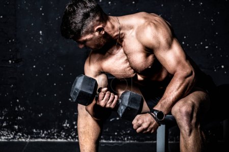 Foto de Young strong serious sweaty focused athlete fit muscular man with big muscles holding heavy kettlebell weight barbell iron for swing crossfit training hard core workout in the gym - Imagen libre de derechos