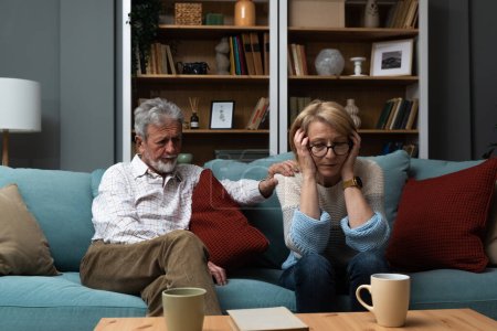 Triste femme mûre assise loin de son mari après s'être disputée. Couple de personnes âgées ne parlant pas se disputer à leur domicile. Crise du mariage problèmes relationnels.