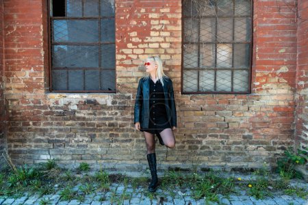 Junge schöne starke unabhängige Rebellin blonde Frau Punk-Musik und Stil-Fan posiert. Selbstbewusstes Punk-Rock Jugendkultur Streetstyle-Konzept. Coole Einstellung und anderes Konzept