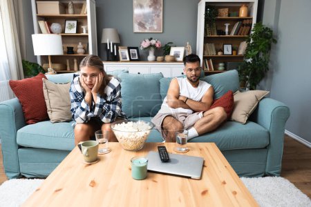 Communication problems, relationship difficulties. Young couple man and woman sitting on sofa at home, not talking after argue and misunderstanding. Two sad people having issue with ego and guilt.