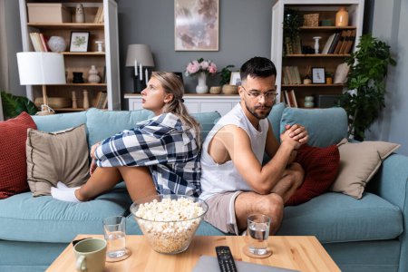 Communication problems, relationship difficulties. Young couple man and woman sitting on sofa at home, not talking after argue and misunderstanding. Two sad people having issue with ego and guilt.