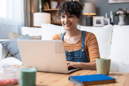 Kopfschuss angenehme glückliche junge Frau freiberufliche Arbeit am Computer zu Hause. Attraktive Geschäftsfrau, die online studiert, Laptop-Software nutzt, im Internet surft oder im Internet einkauft.