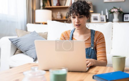 Kopfschuss angenehme glückliche junge Frau freiberufliche Arbeit am Computer zu Hause. Attraktive Geschäftsfrau, die online studiert, Laptop-Software nutzt, im Internet surft oder im Internet einkauft.