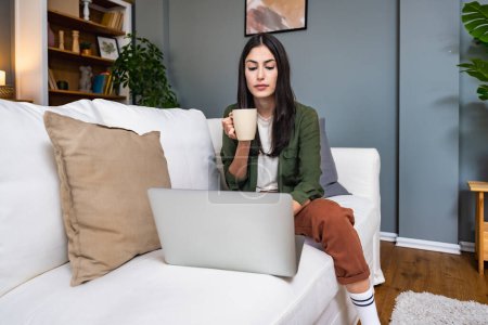 Young introvert freelancer businesswoman with ADHD working remotely from home office on laptop computer. Business person avoiding crowded office and people by working alone at apartment on computer.