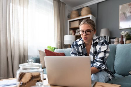 Young introvert freelancer businesswoman with ADHD working remotely from home office on laptop computer. Business person avoiding crowded office and people by working alone at apartment on computer.