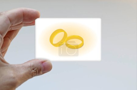 Foto de Hand holding card decorated with golden rings - Imagen libre de derechos
