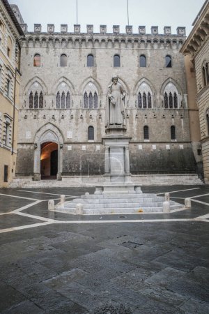 Photo for Siena, Italy - 22 Nov, 2022: Piazza Salimbeni, Banca Monte dei Paschi di Siena, and the state of Sallustio Bandini - Royalty Free Image