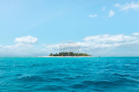 Eine kleine bewohnte Insel umgeben von türkisfarbenem Wasser an einem sonnigen Tag, das perfekte Luxus-Urlaubsziel Fidschi