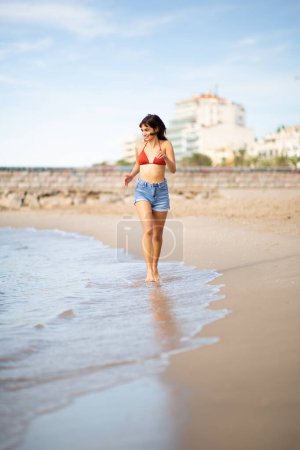 Photo for Full length portrait of beautiful young woman running on the beach - Royalty Free Image