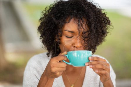 Téléchargez les photos : Gros plan portrait jeune femme buvant du café à l'extérieur - en image libre de droit