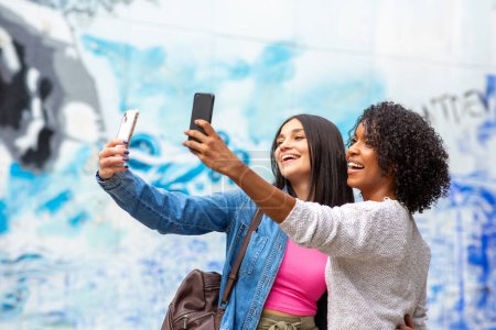 Téléchargez les photos : Portrait souriant de jeunes femmes prenant selfie ensemble - en image libre de droit