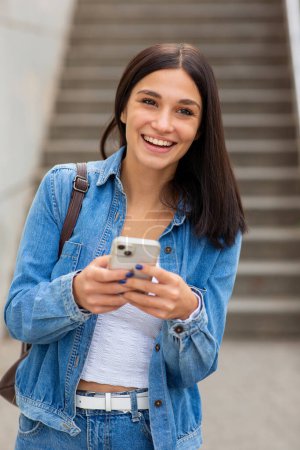 Foto de Retrato feliz sonriente joven mujer sosteniendo el teléfono móvil - Imagen libre de derechos