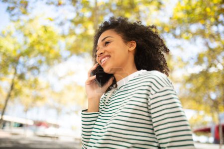 Téléchargez les photos : Portrait souriant afro-américain fille parler avec téléphone portable - en image libre de droit