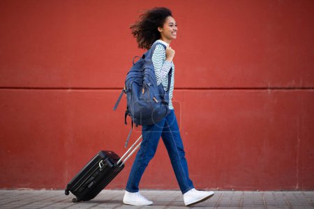 Photo for Full length portrait young travel woman pulling suitcase - Royalty Free Image