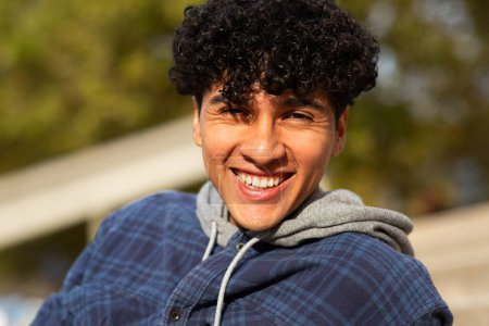 Téléchargez les photos : Gros plan portrait jeune homme souriant aux cheveux bouclés - en image libre de droit