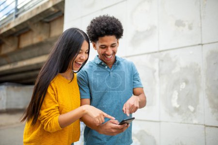 Téléchargez les photos : Portrait jeune couple heureux pointant vers les téléphones mobiles - en image libre de droit