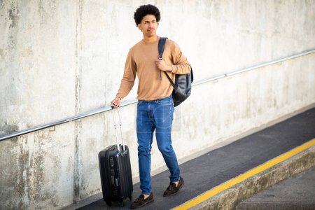 Téléchargez les photos : Portrait complet jeune homme de voyage afro-américain marchant avec des sacs - en image libre de droit