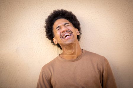 Téléchargez les photos : Gros plan portrait de heureux jeune homme afro-américain avec des accolades riant - en image libre de droit