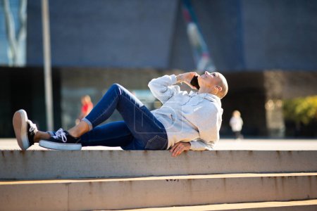 Téléchargez les photos : Portrait de femme relaxant à l'extérieur avec téléphone portable - en image libre de droit