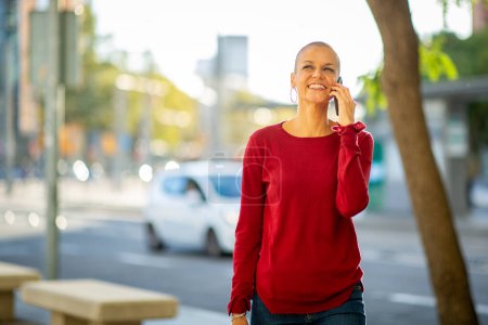 Foto de Retrato de mujer de mediana edad con peinado moderno hablando por celular en la ciudad - Imagen libre de derechos