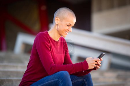 Téléchargez les photos : Portrait de femme assise avec téléphone dans les mains - en image libre de droit
