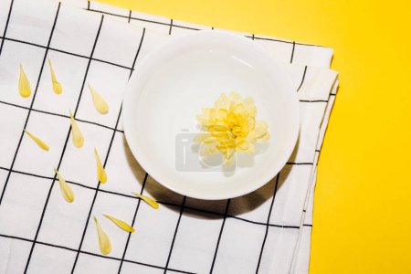 Foto de Flor de crisantemo amarillo en un tazón de agua de meditación. Procedimientos de relajación. SPA, cosmetología. - Imagen libre de derechos