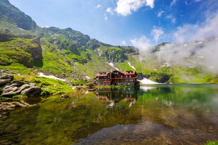 Téléchargez les photos : Paysage alpin de montagnes de fagaras. Balea lac de Roumanie en été. temps ensoleillé avec nuages sur le ciel bleu. taches de neige et d'herbe sur le versant rocheux. décor reflétant dans l'eau - en image libre de droit