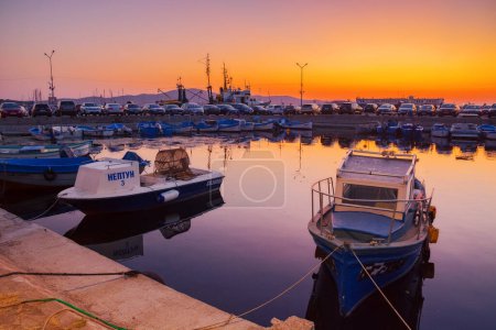 Téléchargez les photos : Sozopol, bulgaria - 03 sep 2019 : petits bateaux de pêche dans le port au crépuscule. ciel sans nuages se reflétant dans l'eau - en image libre de droit