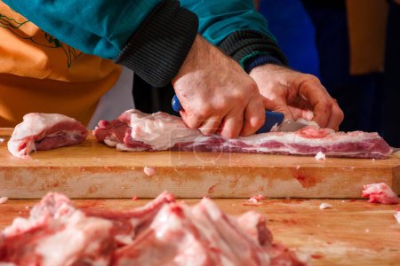 Téléchargez les photos : Hecha, Ukraine - 27 juin 2018 : Concours de bouchers de porc. processus de préparation de la viande pour la soupe traditionnelle hongroise de goulache bogracs. découper la chair sur la planche de bois - en image libre de droit