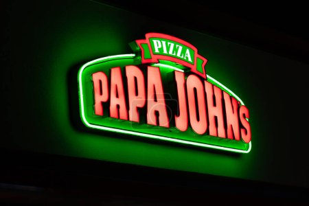 Photo for STILLWATER, MN, USA - DECEMBER 7, 2023:Papa John's lit exterior resturaunt sign at night and trademark logo. - Royalty Free Image