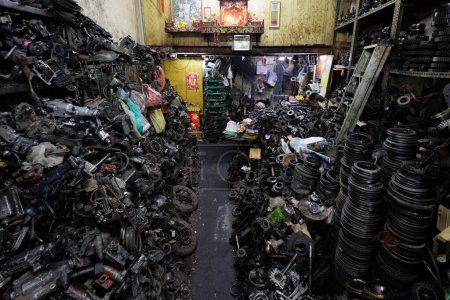 Un magasin de véhicules rempli de pièces et d'outils anciens, l'atmosphère est chaotique et désorganisée, Chinatown de Bangkok, Thaïlande