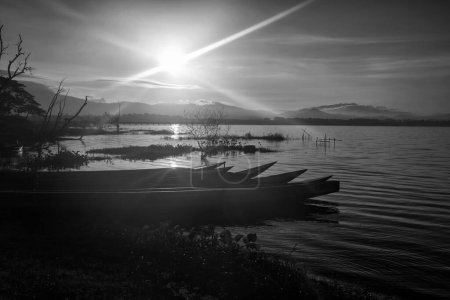 Photo for Fisherman wooden boats over bang phra reservoir against sunrise, Siracha, Chonburi, Thailand. Famous travel destination or summer holiday vacation in tropical country. Black and white color process. - Royalty Free Image