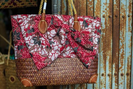 Téléchargez les photos : Weave rattan woman shoulder bag  with red ribbon to sell in vintage store at Chanthaburi old building village, Thailand. - en image libre de droit