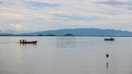 Téléchargez les photos : Fishermen sailing long tail boats with flying bird at sea in Kung Krabaen Wildlife Reserve, Chanthaburi, Thailand. - en image libre de droit