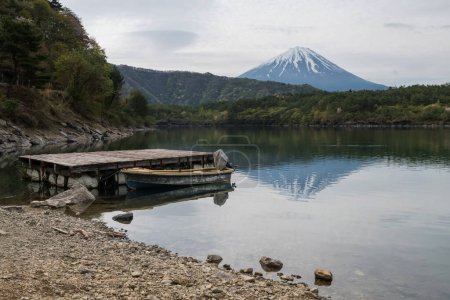 Photo for Mt.Fuji and floating boat on Lake Saiko in morning with skyline reflection, Yamanashi, Japan. Famous travel destination and holiday vacation maker. - Royalty Free Image