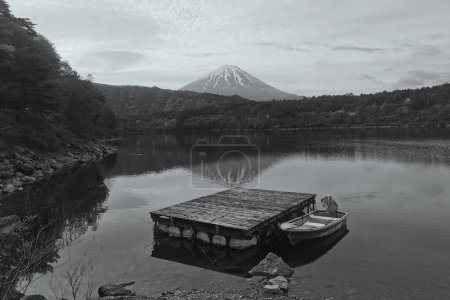 Photo for Mount fuji and floating boat on Lake Saiko in morning with skyline reflection, Yamanashi, Japan. Famous travel destination and holiday vacation maker. Black and white process. - Royalty Free Image