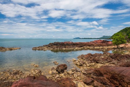 Téléchargez les photos : Man fishing on pink arkosic sandstone rocks at sea coast agianst blue sky in Kung Krabaen Wildlife Reserve, Chanthaburi, Thaïlande. Destination de voyage célèbre à l'Est du Siam ou en Thaïlande. - en image libre de droit
