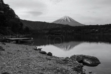 Photo for Lake Saiko with floating boat and mount Fuji in morning with skyline reflection, Yamanashi, Japan. 1 of 5 famous Fuji lakes to make holiday vacation maker. Black and white process. - Royalty Free Image