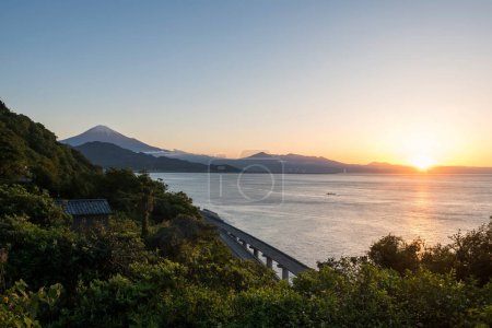 Photo for Mt. Fuji and expressway seen from Satta Toge pass at sunrise with reflection on sea, Shimizu, Shizuoka, Japan. Famous photography top view spot for tourist people. - Royalty Free Image