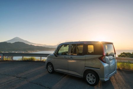 Photo for Minivan car park at Satta Toge pass viewpoint spot against mount Fuji and sunrise in early morning, Shimizu Ward, Shizuoka, Japan. Famous travel destination. - Royalty Free Image