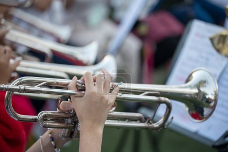 Musikerhände halten und Trompeten spielen bei Konzert der Schulband