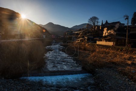 Foto de Shibu onsen city with cascading river at sunrise, Yamanouchi, Nagano, Japan. La ciudad es famosa por las aguas termales y el parque de nieve de monos Jigokudani. - Imagen libre de derechos
