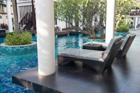 Liegestühle auf der Terrasse der Villa mit Swimmingpool im Luxusresort. Zugang zum Pool vom Zimmer aus.